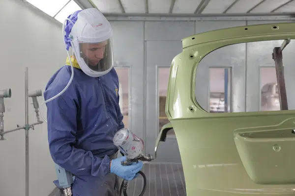 Panel beating technician shaping a damaged door panel back to manufacturer specification